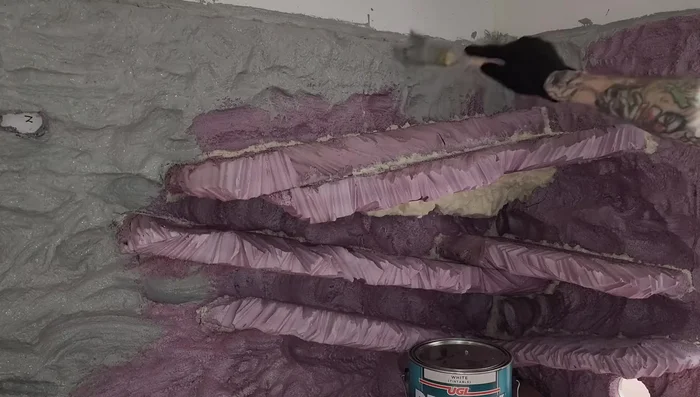 Attach the hide to the background using spray foam and carve it to look like rock.