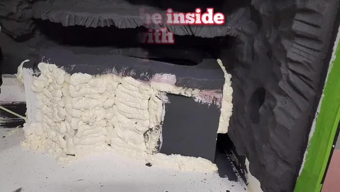 Attach the hide to the background using spray foam and carve it to look like rock.