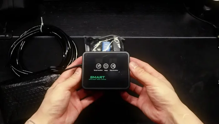 Unbox the Migi Kaka system. Components include: smart box, nozzles, zip ties, brackets, water filtration system, connector pieces, cable cutters, and instructions.