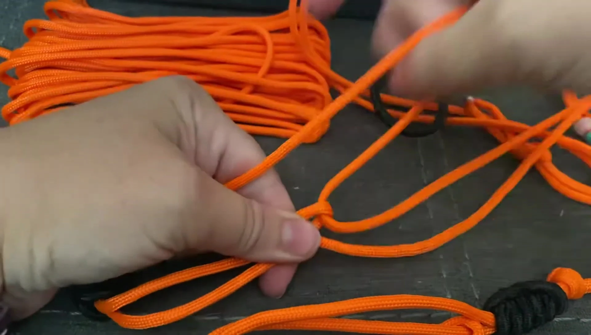 Threading one end of the paracord through the loop.