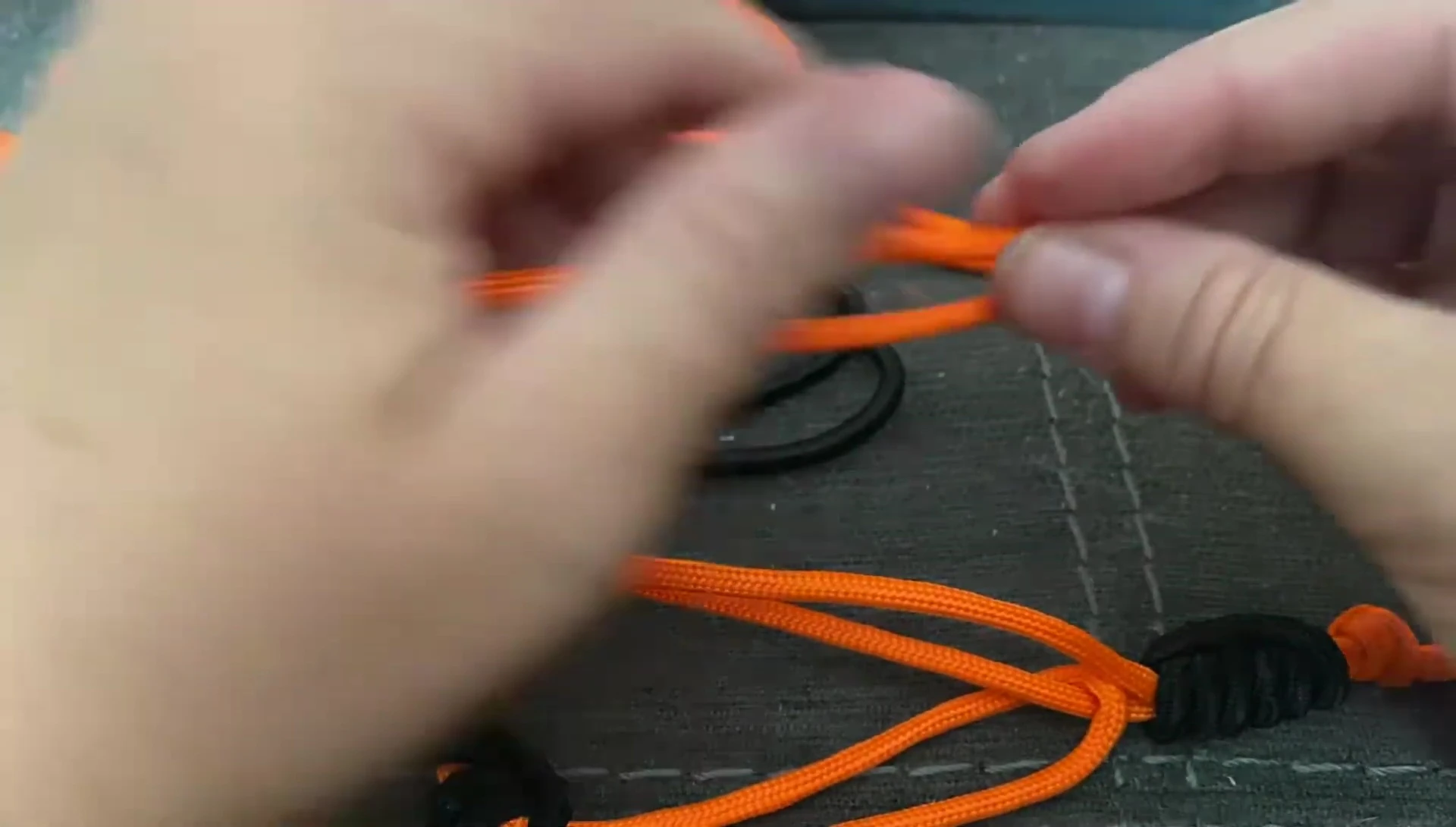 Doubled-over paracord being prepared for the first hair elastic.