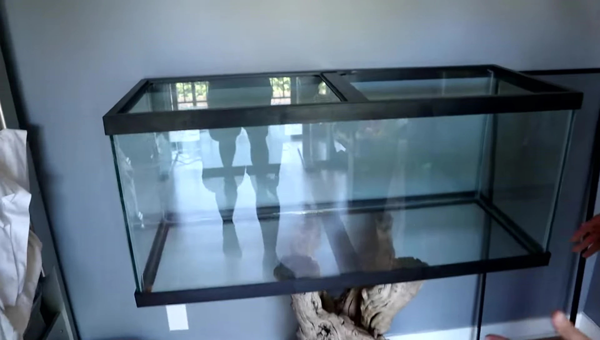 The YouTuber laying down next to the tank to show its size.