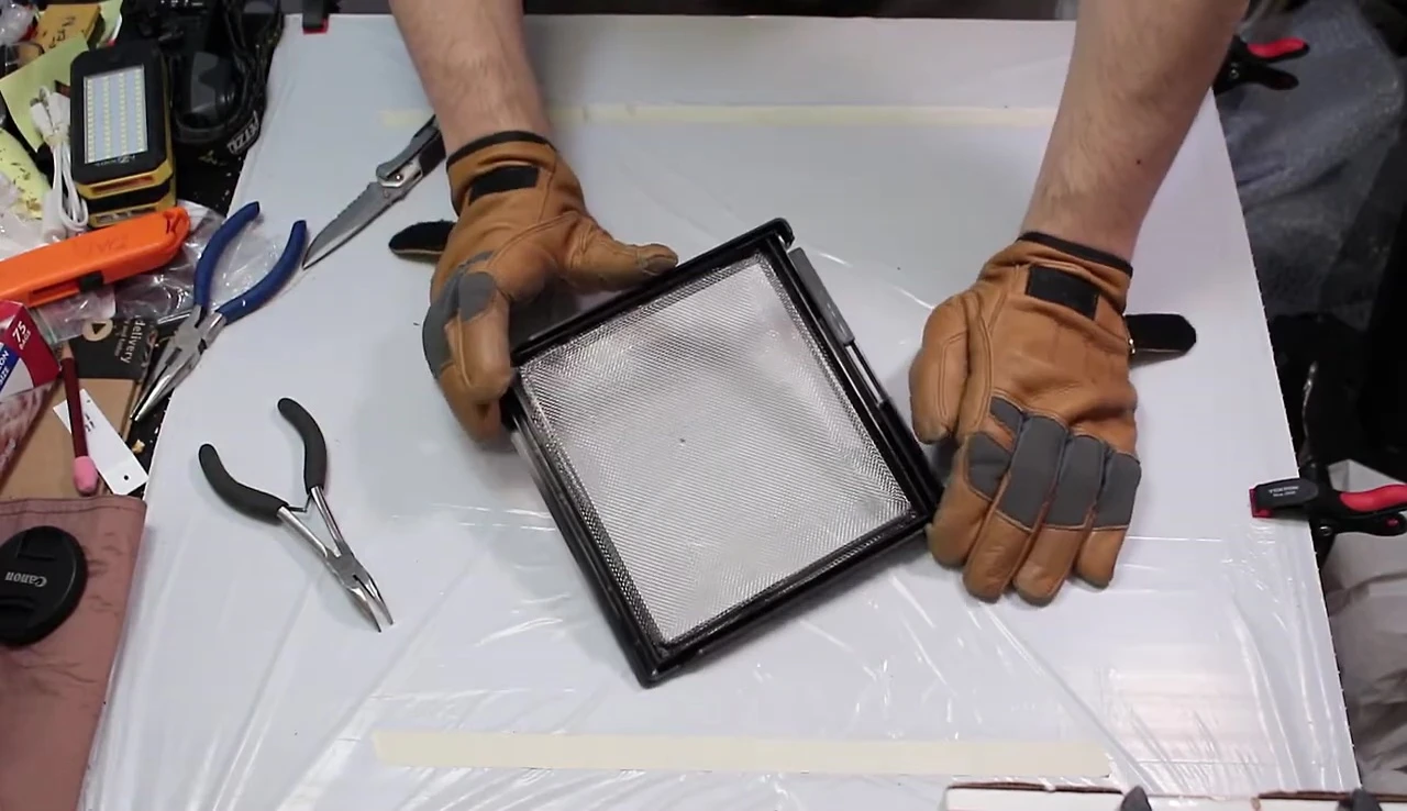 Removing the screen mesh from the frame.