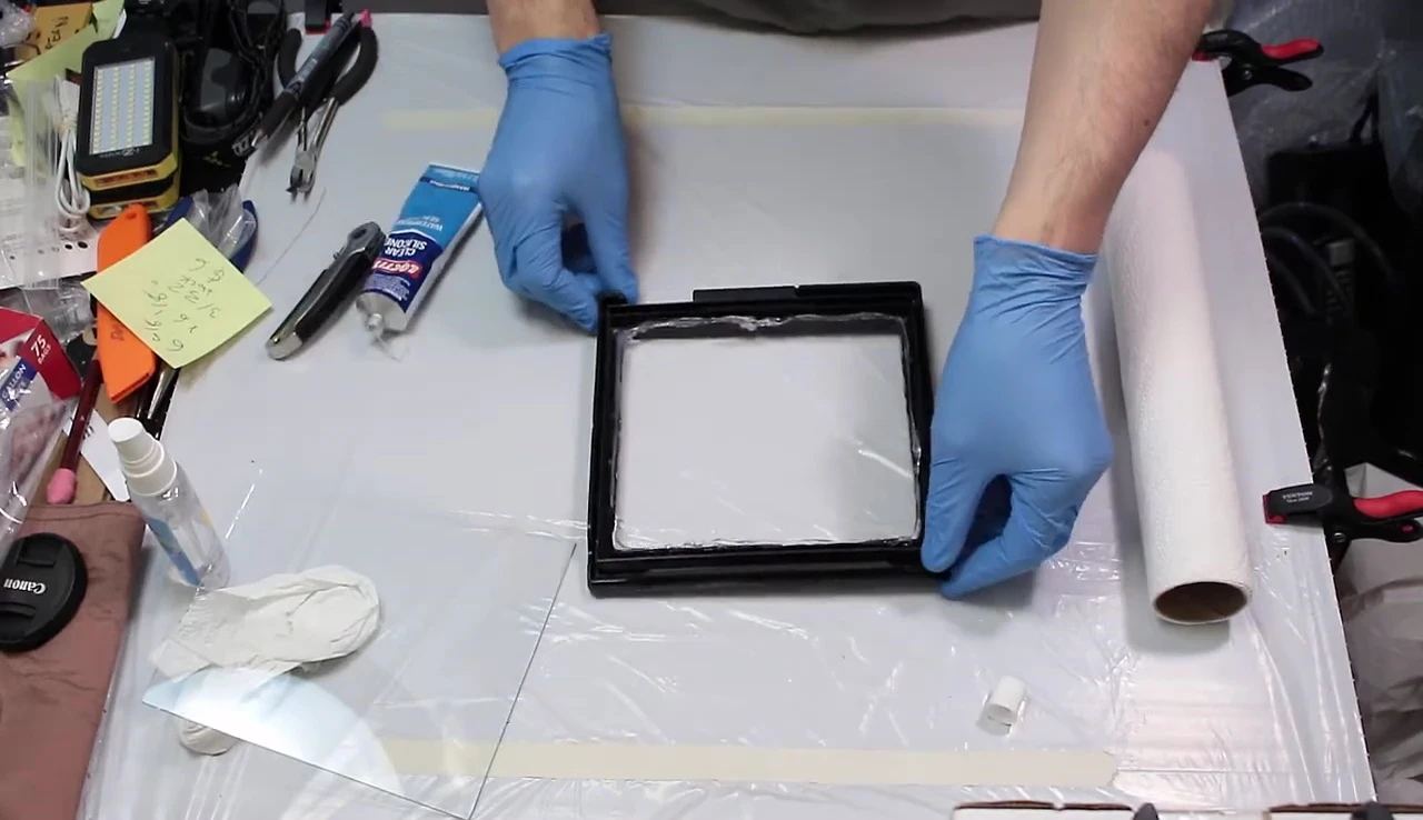 Securing the glass panel with silicone.
