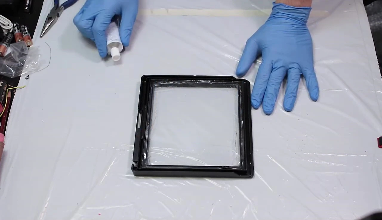 Applying silicone sealant to the inside of the frame.