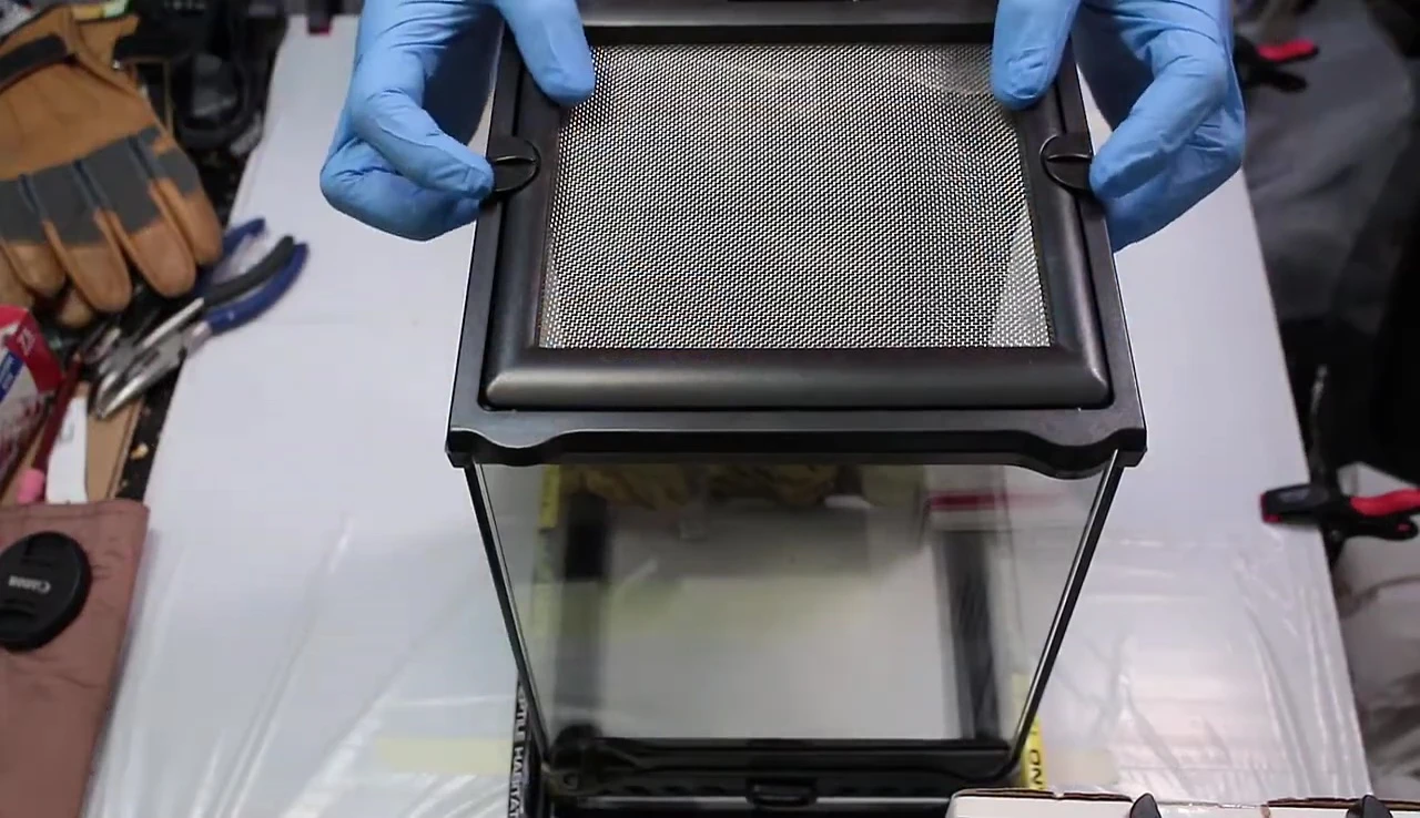 Unlocking the lid of the Exo Terra Nano terrarium.