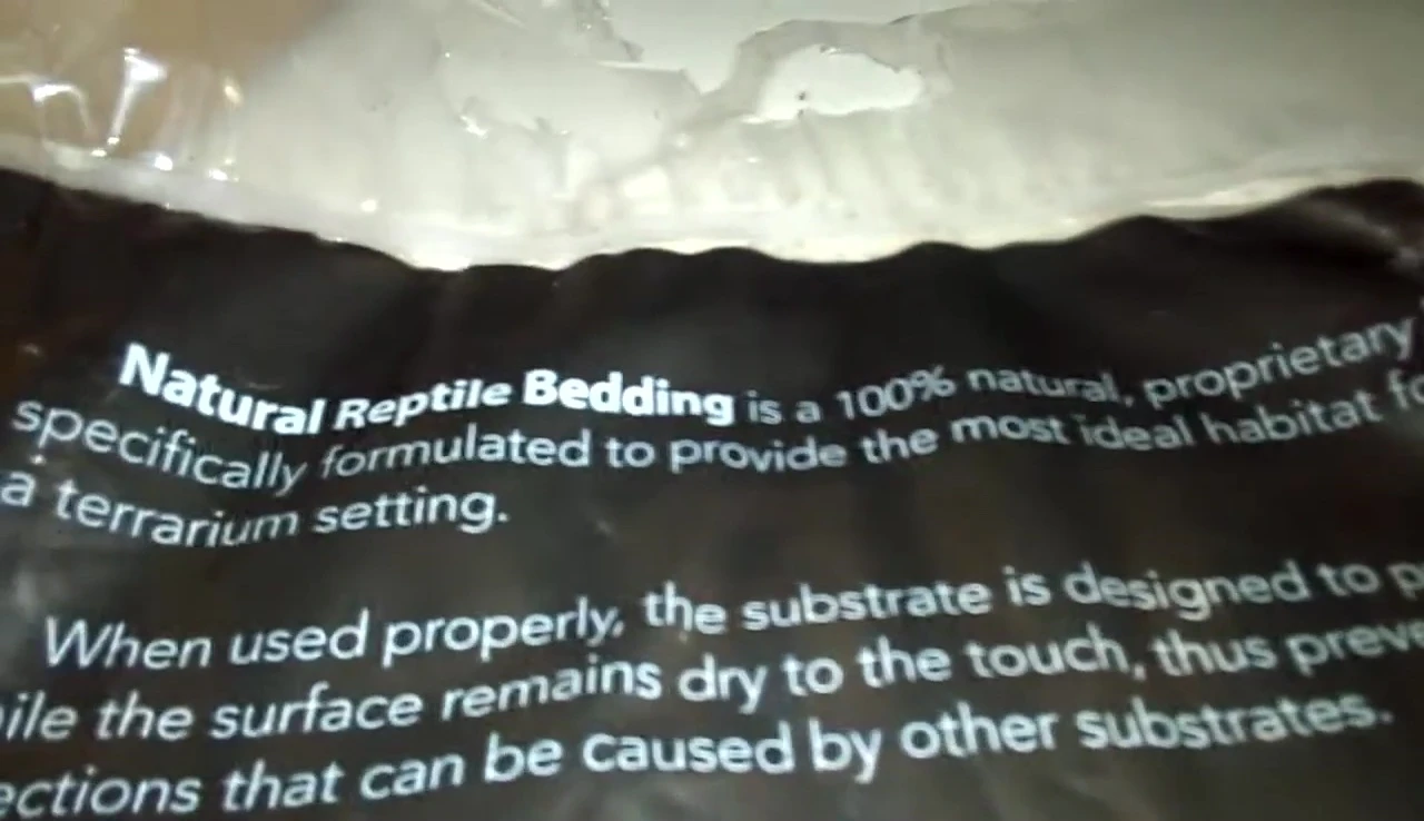 Close-up shot of the Lugarti Natural Reptile Bedding packaging, highlighting the '100% natural' claim.