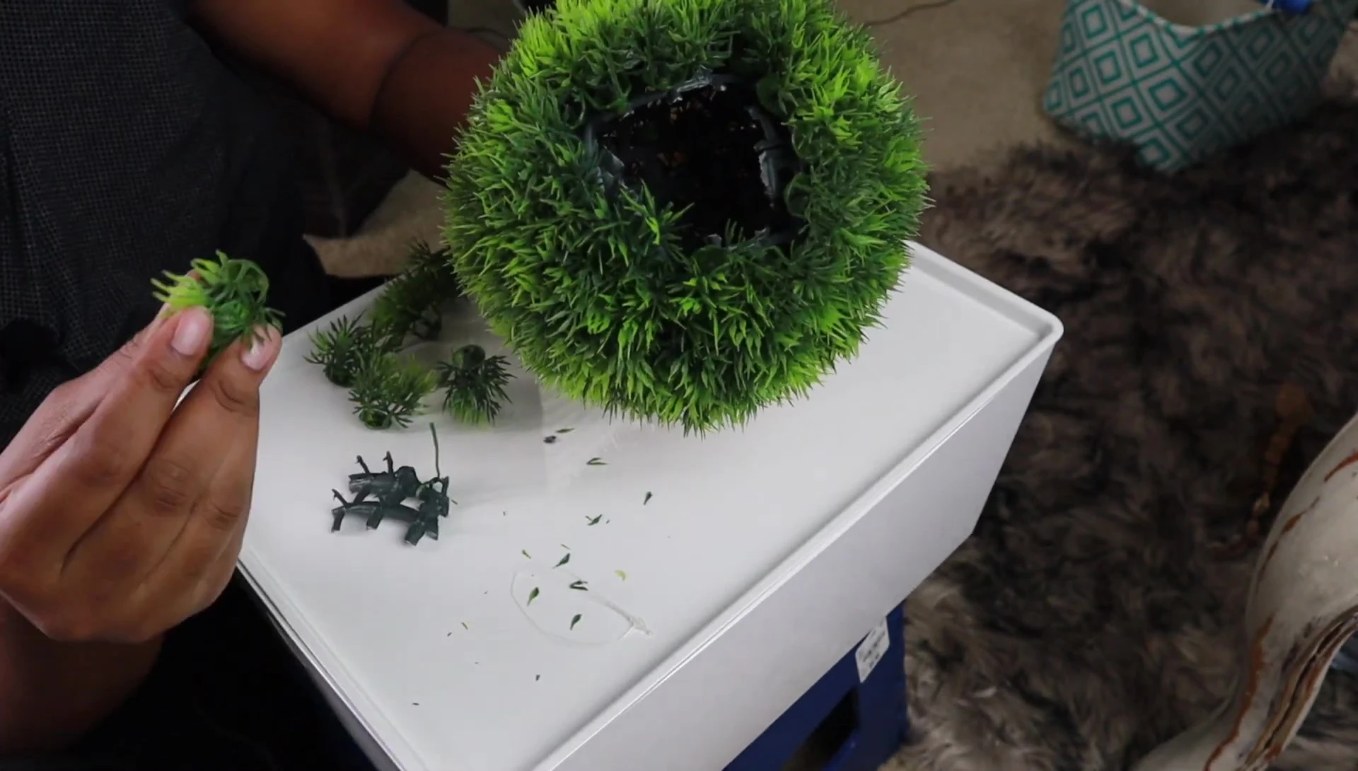 Hot glue being used to attach decorative pieces to the edges of the opening.
