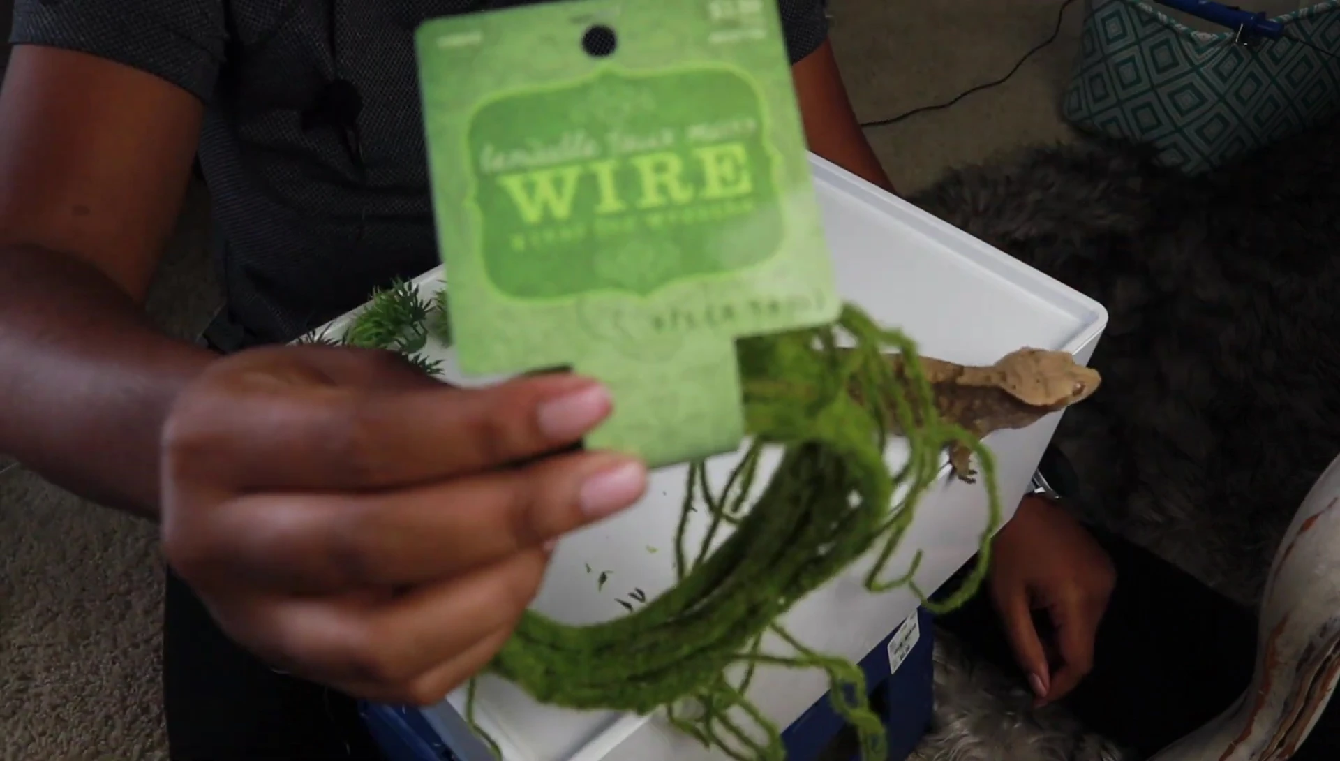 The speaker shows the bendable foam wire used to hang the moss ball.