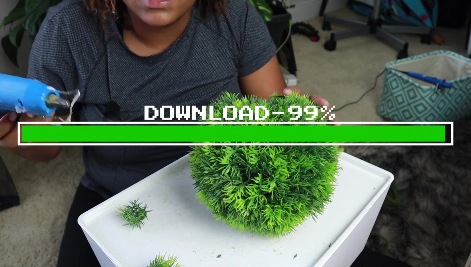 Using hot glue to secure the wire to the moss ball and create a neat finish.