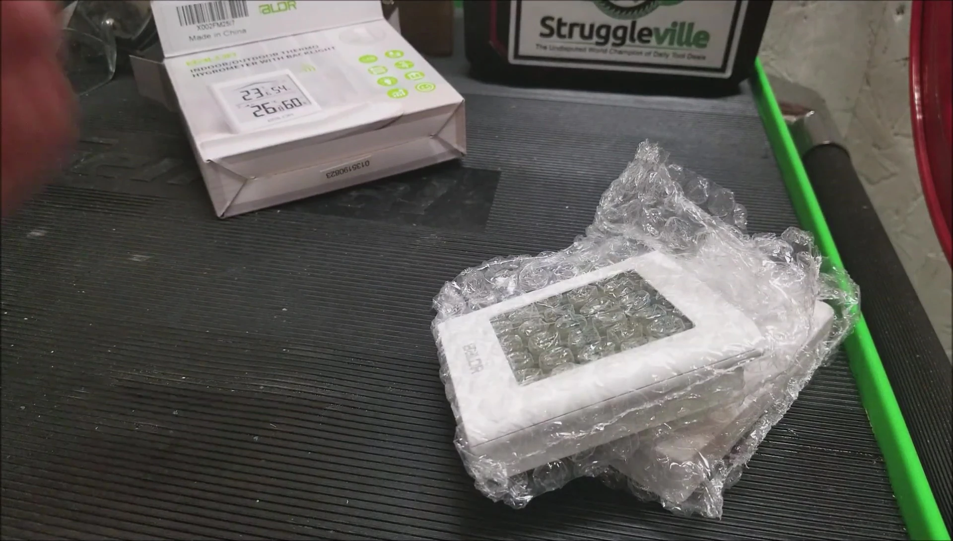 Unboxing the Zupora thermo-hygrometer, showing the contents: indoor unit, outdoor sensor, and instructions.