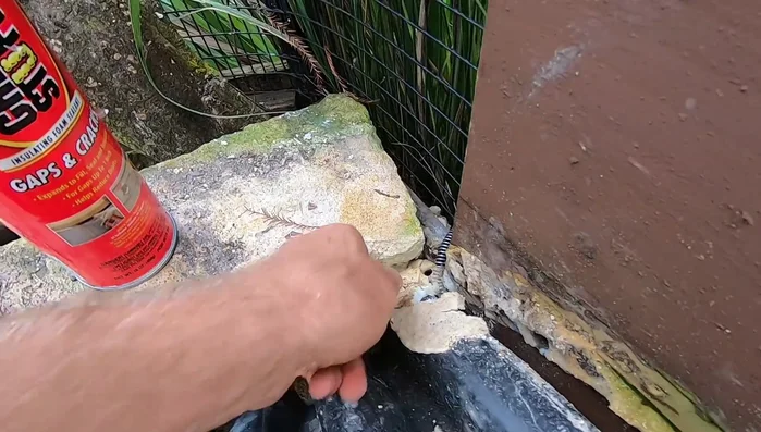 Apply expandable foam to seal gaps and crevices around the cave entrance.