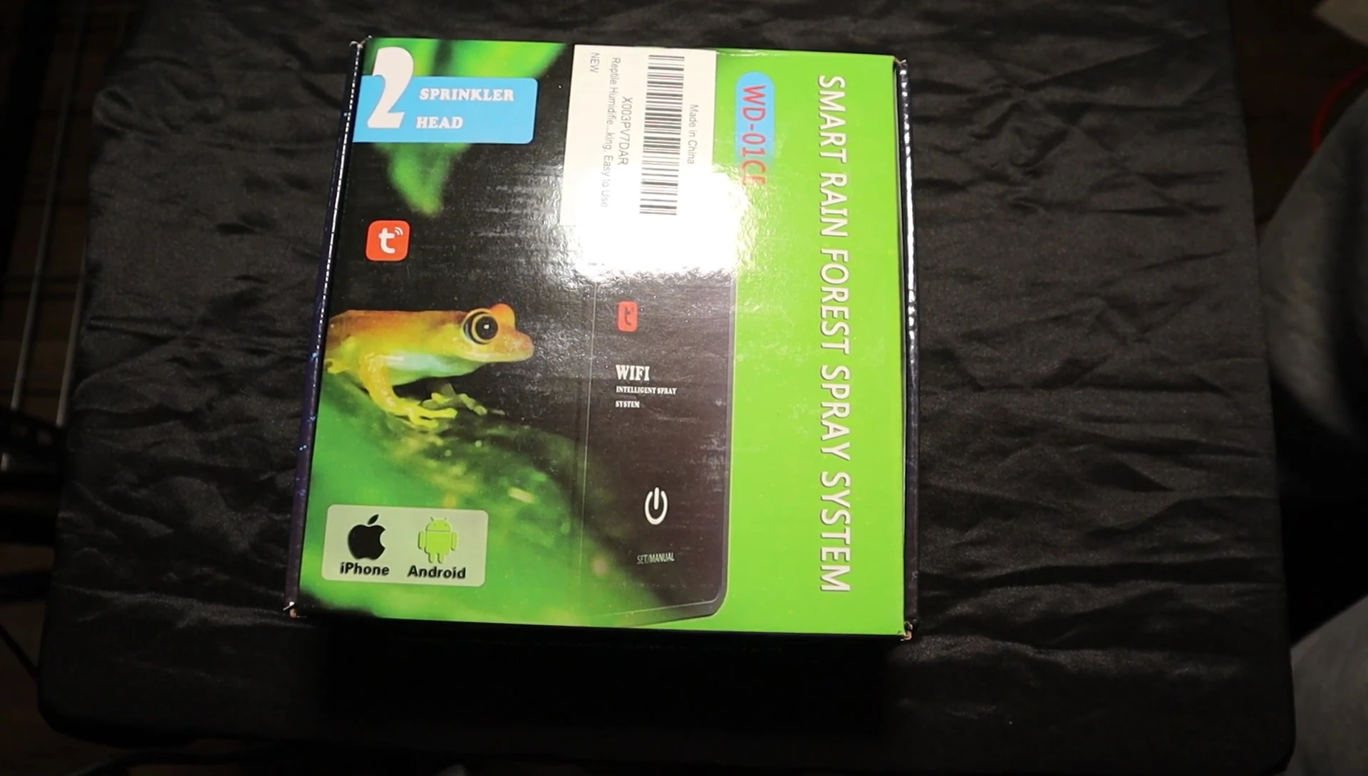 The unboxing begins, showing the outer packaging of the smart rainforest spray system.