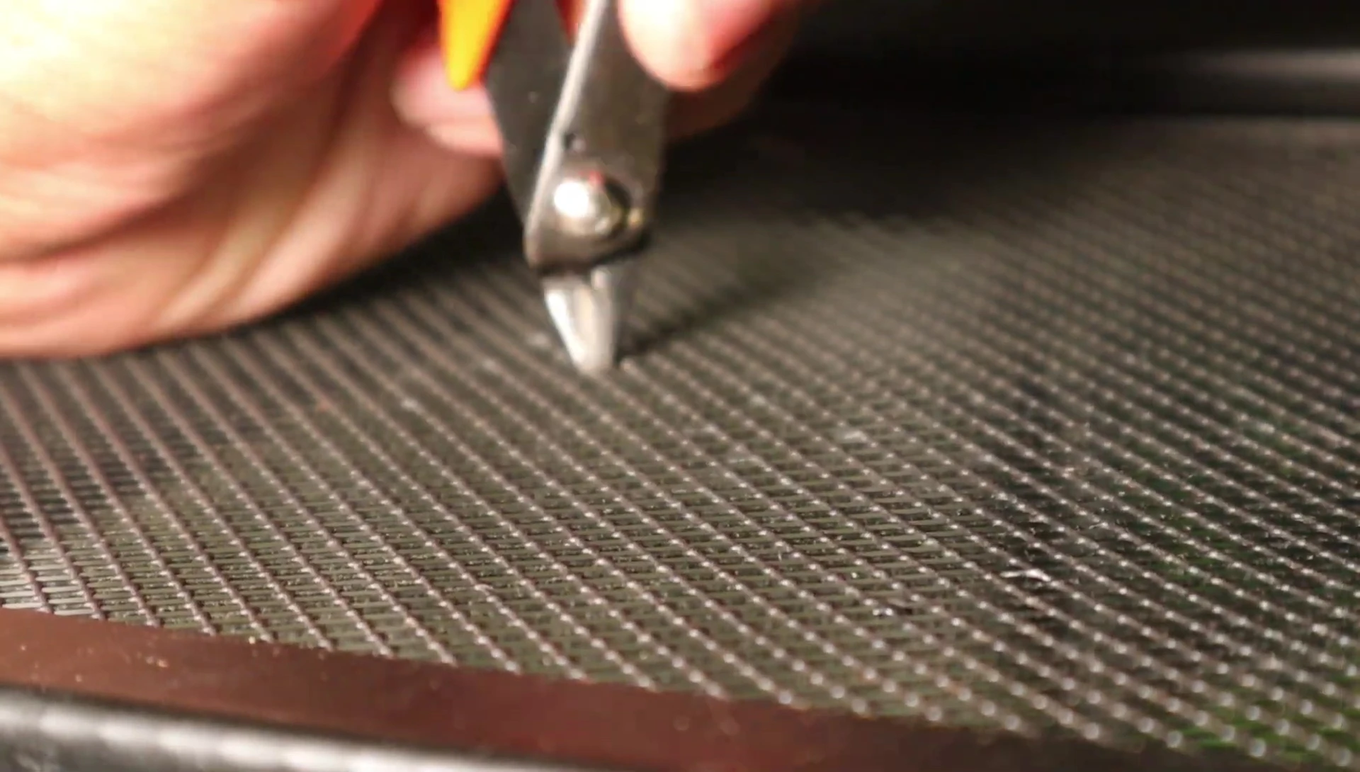 The presenter prepares to cut an opening in the enclosure for a spray nozzle.