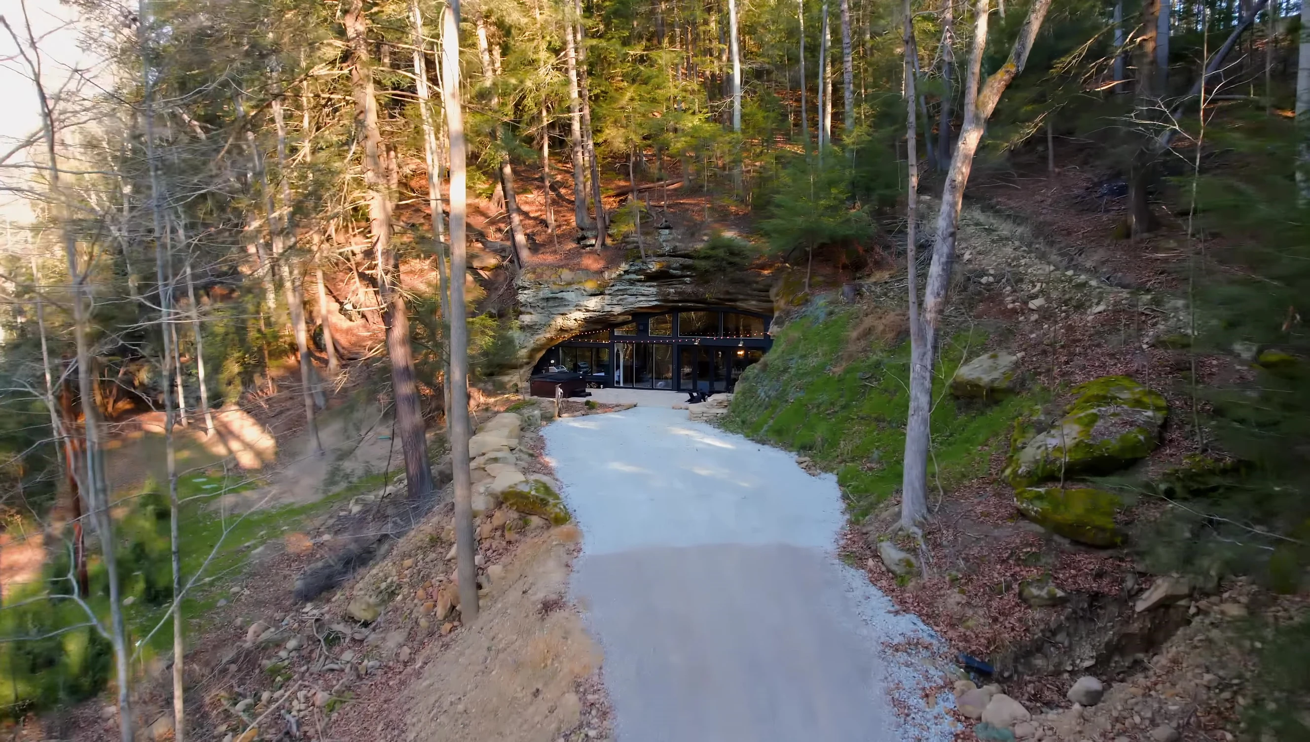 Exterior view of the cave house, showcasing the driveway and surrounding natural landscape.