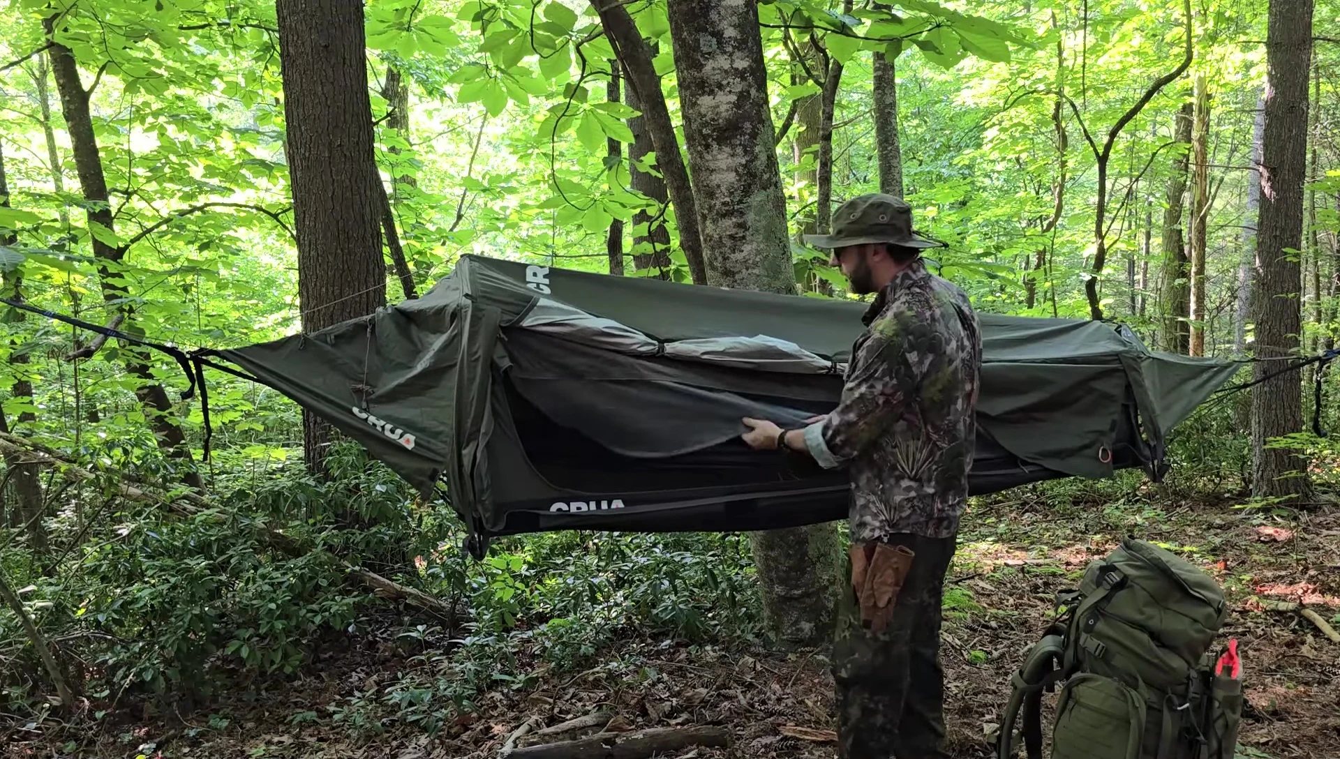 The hammock tent with one side rolled up for ventilation.
