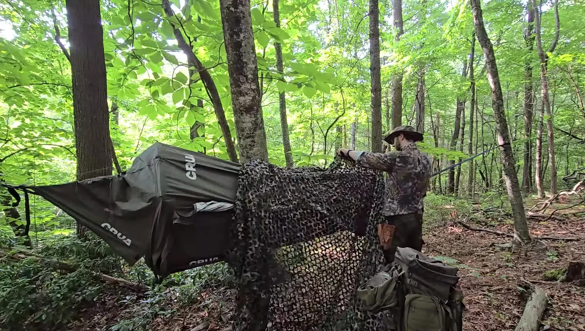 The camouflage netting draped over the hammock.