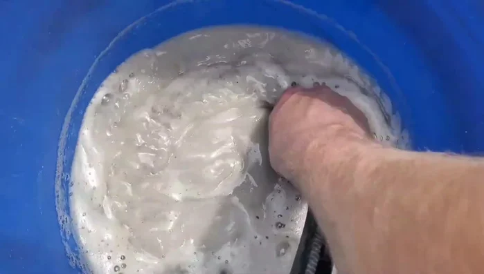 Carefully siphon or remove the dirty water from the top of the bucket, leaving the sand behind.