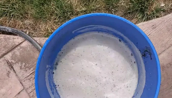 Carefully siphon or remove the dirty water from the top of the bucket, leaving the sand behind.
